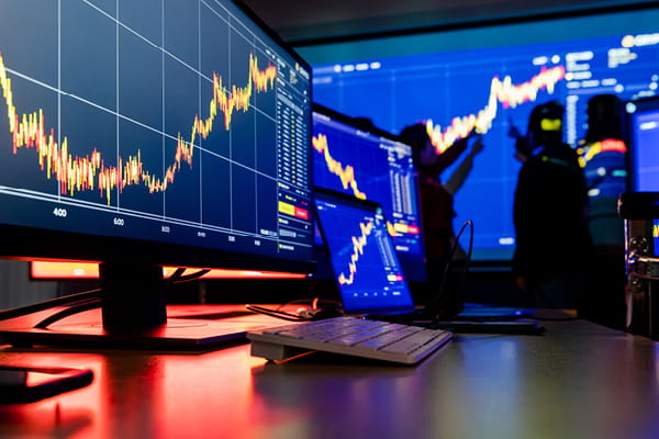 A digital display shows a blue stock market graph in the background.