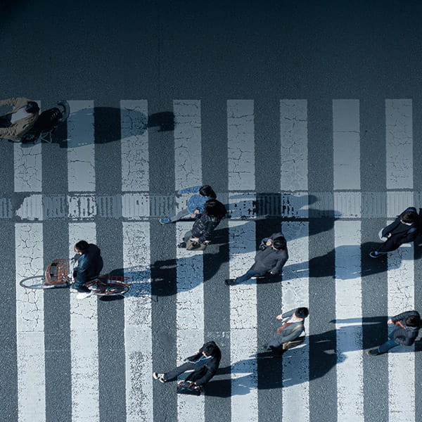 Cyclist and pedestrians walking over zebra crossing