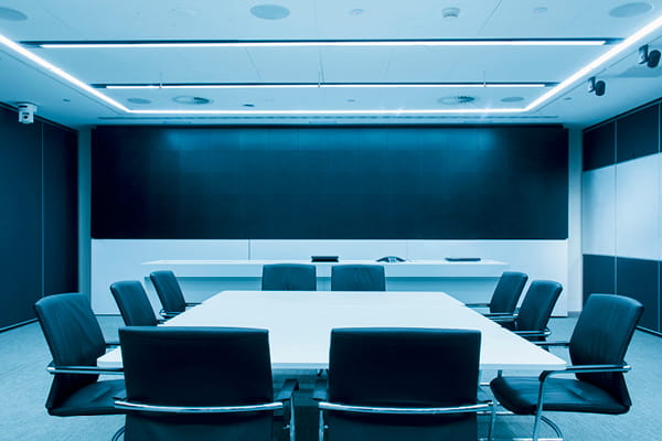 A conference room with a white table and black chairs, included in the Ahead of the Deal M&A Briefing article series.